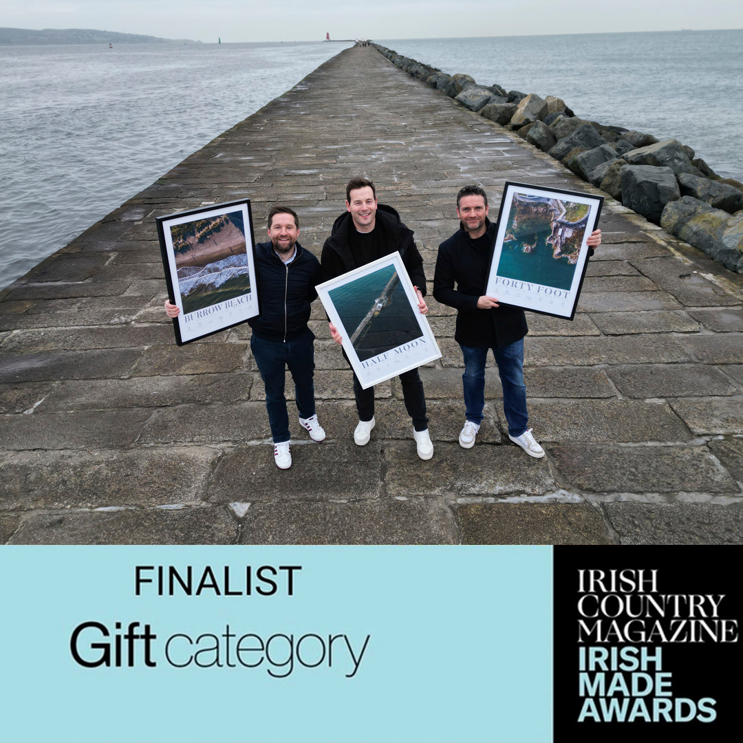 Picture of the three owners of Love Your Spot on the Bull Wall in Dublin holding examples of their prints.