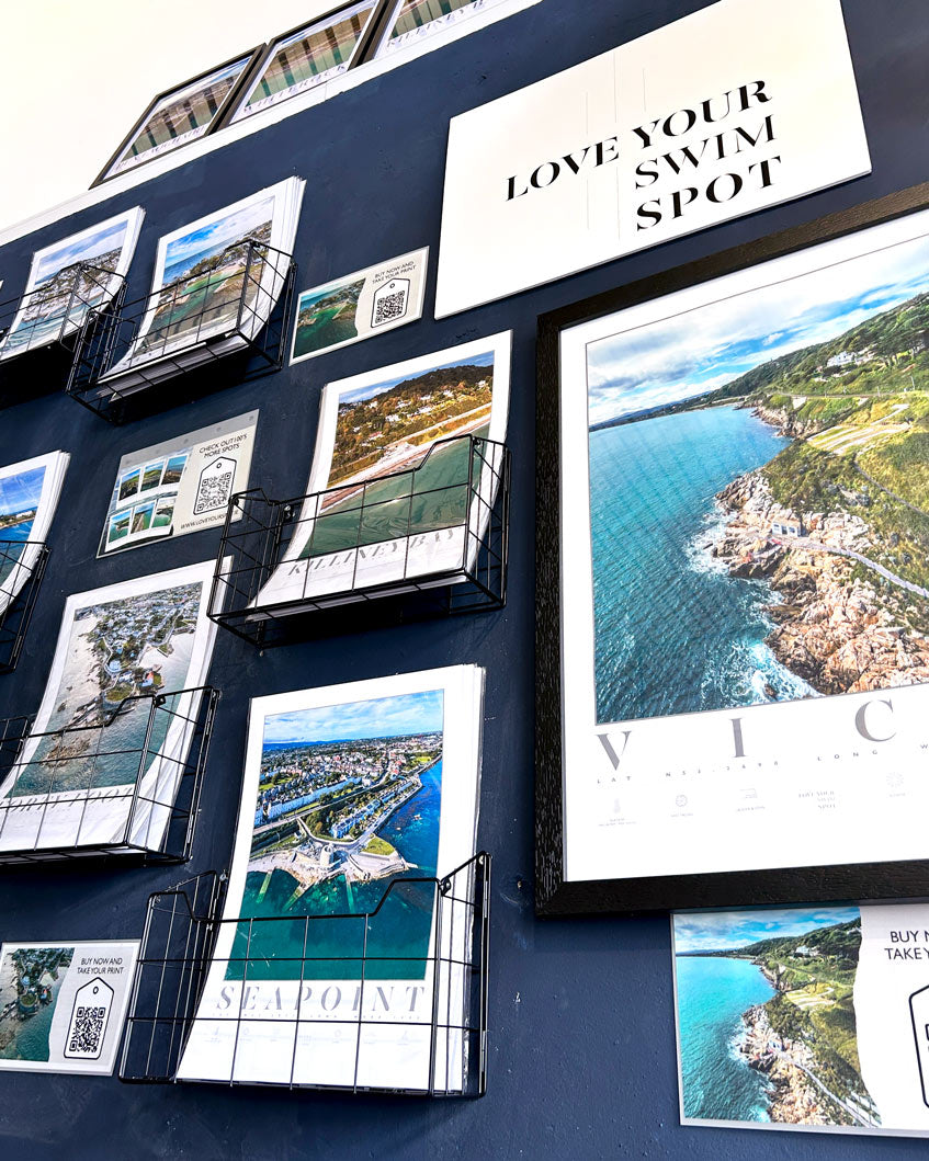 collection of Love Your Spot Swim spot prints being displayed on a wall of a shop for sale
